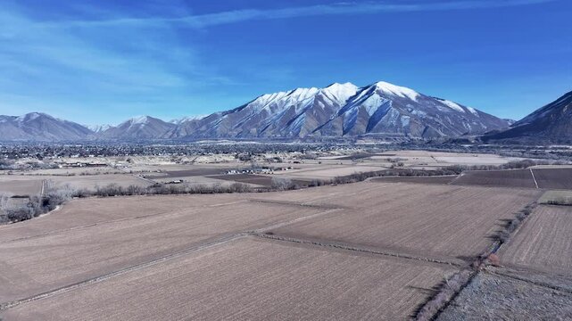 Aerial Payson Utah city mountain valley farms. Urban and rural landscape in mountain valley. Rapidly growing population, homes, business and schools. Neighborhood parks and recreation fields.