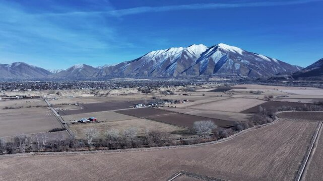 Aerial Payson Utah city mountain valley farms slide. Urban and rural landscape in mountain valley. Rapidly growing population, homes, business and schools. Neighborhood parks and recreation fields.