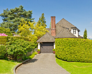 Garage door in luxury house with trees and nice landscape in Summer in Vancouver, Canada, North America. Day time on June 2024.