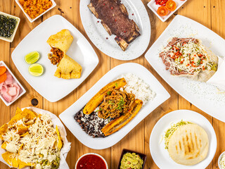 Comida arroz con plátano frito y frejoles, tacos, carne a la parrilla y empanada argentina, arepas, bodegón cenital