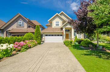 Garage door in luxury house with trees and nice landscape in Summer in Vancouver, Canada, North America. Day time on June 2024.