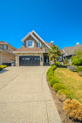 Garage door in luxury house with trees and nice landscape in Summer in Vancouver, Canada, North America. Day time on June 2024.