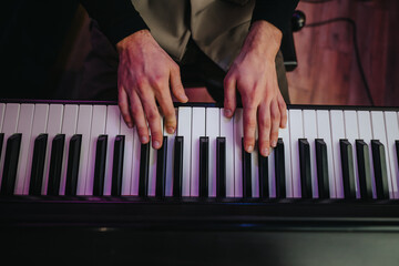 A detailed view of a musician's hands playing the piano, focusing on finger placement and movement....