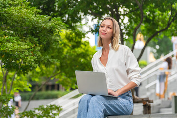 Caucasian Woman Using Laptop to Work While Sitting Outdoor a Park