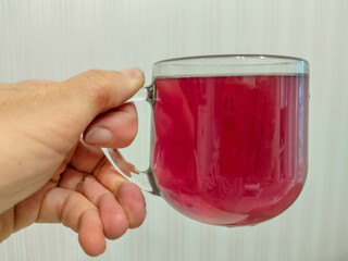 a cup of red tea in the girl's hand
