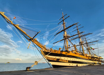 A large old ship at pier under a beautiful blue sky