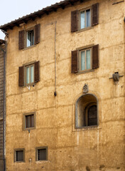 Exterior view of an old building with a recessed arched window, Florence