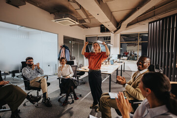 Business coworkers engaging in a vibrant group meeting, showing excitement and teamwork. The...