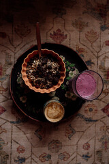 Healthy breakfast with smoothie and granola on bohemian background