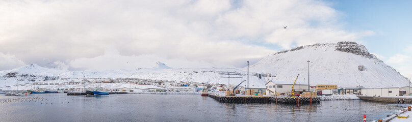 Fototapeta premium Panoramic snowy fishing town by the water
