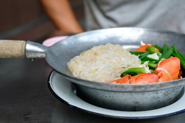 Steamed mud crab with glass noodles, green onions and chives served with nam jim jaew (seafood dipping sauce) at a street food cart in Khlong San - Bangkok, Thailand