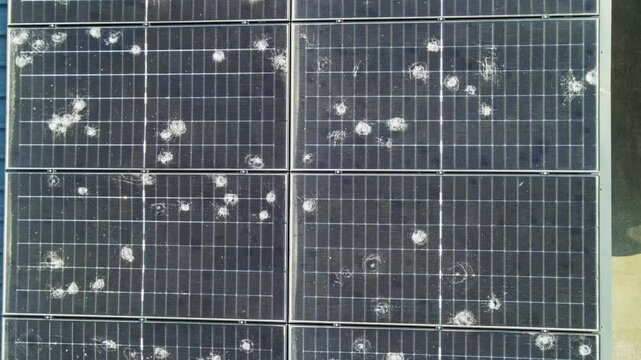 Drone 4k footage of solar panels on a house roof severely damaged by a recent hailstorm. Captures the fragility of renewable energy systems under extreme weather conditions. Climate change theme video
