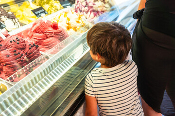 Boy choosing ice cream from display on summer holidays in piran, slovenia