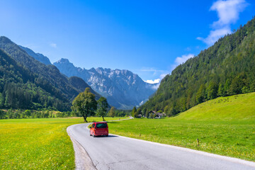 Red van driving through logarska dolina valley in slovenia during summer © unai