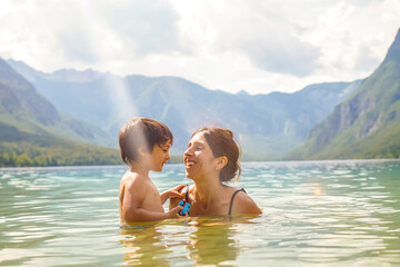 Mother and son playing together in lake bohinj, slovenia