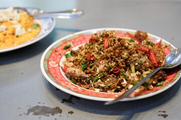 A dish of rice with stir-fried crab curry and chilli and salt fried pork belly at Chula 50 Kitchen in Silom, Bang Rak - Bangkok Thailand