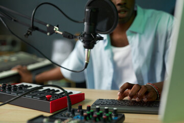 Close-up of African American man playing song in mixing console and singing song