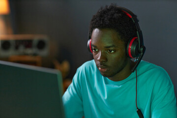 African American man concentrating on his game on computer while sitting at home