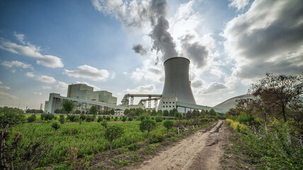 Rural Path Leading to Industrial Cooling Tower Emissions