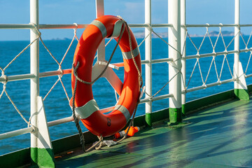Bright Orange Lifebuoy on a Ship's Deck Against a Tranquil Sea