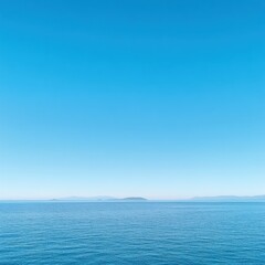 Obraz premium Tranquil Seascape with Clear Blue Sky and Gentle Waves, Capturing Serenity and Calmness Over the Vast Ocean Horizon at Daytime