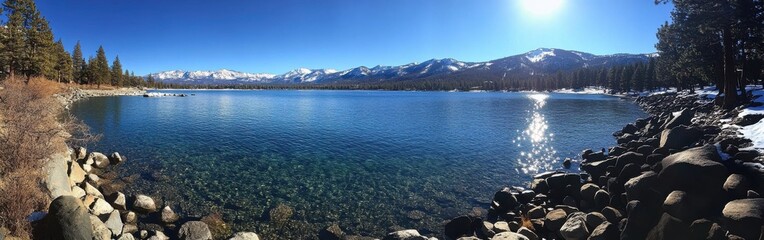 Fototapeta premium Panoramic view of Lake Tahoe showcasing deep blue waters and snowy mountain backdrop during a clear day