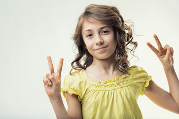 Smiling girl showing victory sign with both hands