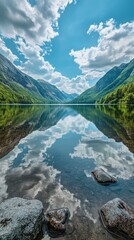 Reflections of clouds and mountains on a serene lake surface in a picturesque landscape during daytime
