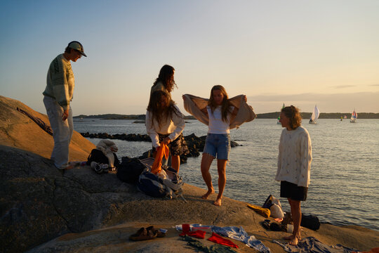 Group of female friends enjoying picnic time on hill at dawn