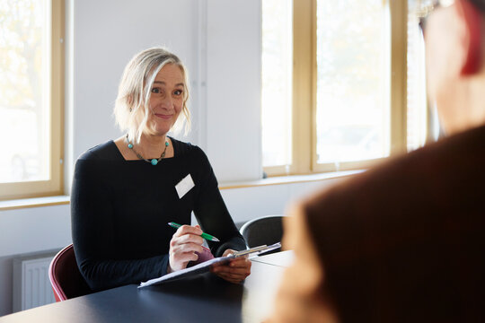 Smiling health worker looking at patient in meeting room