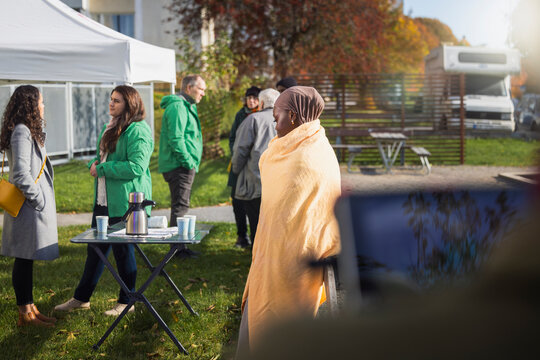 Charity and relief workers talking with needy people at park