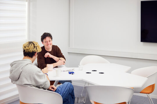 Smiling manager taking interview of medical student in office