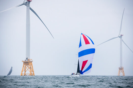 Boats sailing by Wind Turbines in New England