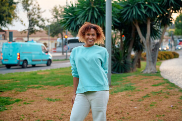 Woman in casual attire enjoys a stroll in the park at sunset in a city