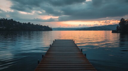 A wooden dock leading to a lake with a beautiful sunset in the background