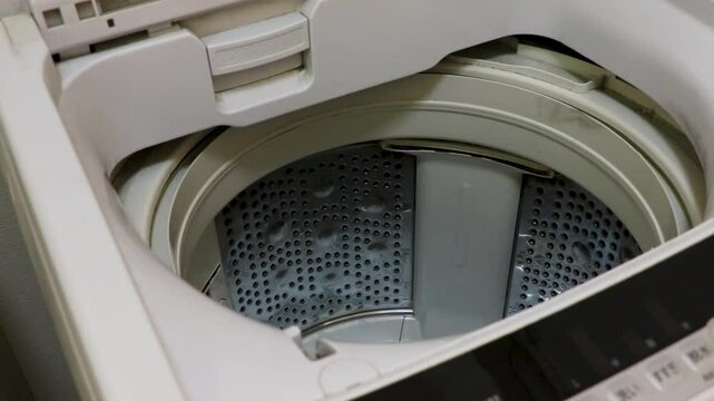 ネットに入れた洗濯物を洗濯機に入れる