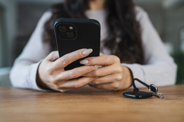 unknown woman hold wireless location accessory token to locate keys