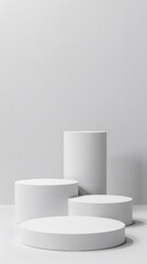 Three white cylindrical platforms against a white background.