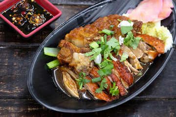 Roasted duck and crispy pork belly on dish with sauce