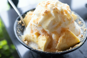 Delicious creamy ice cream in a black bowl Durian Bingsoo a refreshing shaved ice dessert that combines the sweet and unique flavor of durian for the perfect cool treat