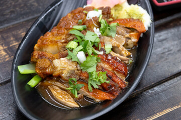 Roasted duck and crispy pork belly on dish with sauce