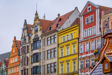 stalls at a Christmas and New Year's market in a big city. Christmas tree decorations and decorations, lights, baubles, garlands against the background of urban architecture, old historic tenement hou