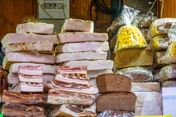 Christmas market in a big city on the street. stalls and wooden booths with regional products. a stand with meat, bacon, home-made bread, pâtés and other meat products.