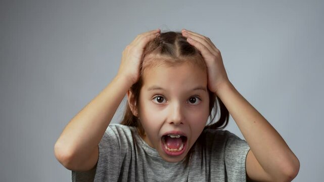 Little aggressive angry girl screaming, looking at camera, close-up