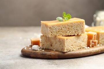 Delicious puffed rice bars, candies and mint on gray textured table, closeup. Space for text