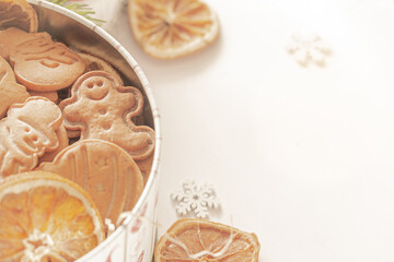 Christmas gingerbread cookies in a tin filled with gingerbread cookies and dried orange slices. Festive food, culinary, festive touch. Christmas and New Year traditions concept, real photo