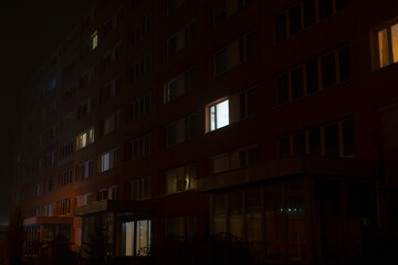 A prominent building that features an abundance of windows is brightly illuminated during the night, creating a stunning visual scene