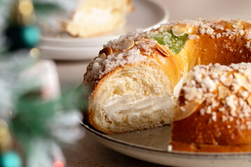 Spanish Three kings cake on decorated table with Christmas tree and burning candles, celebration of Three Kings Day