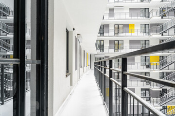 the courtyard of a multi-storey building. a multi-storey hotel , apartment or hostel. Everything is covered with snow. View of the large balconies and windows of the apartment building.