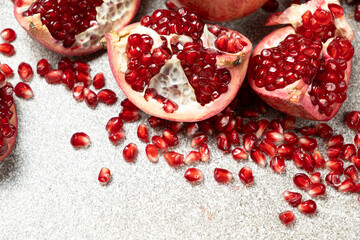 Pomegranate Seeds and Pomegranates on a Stone Gray Background Close-up